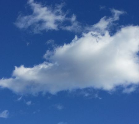 blauer sommerhimmel mit einer weißen Wolke, die vorüberzieht