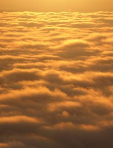 über den Wolken in den goldenen Sonnenuntergang