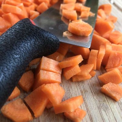 Karotten, Möhren bereits fein geschnitten, mit einem groben Messer auf einem Holzbrett